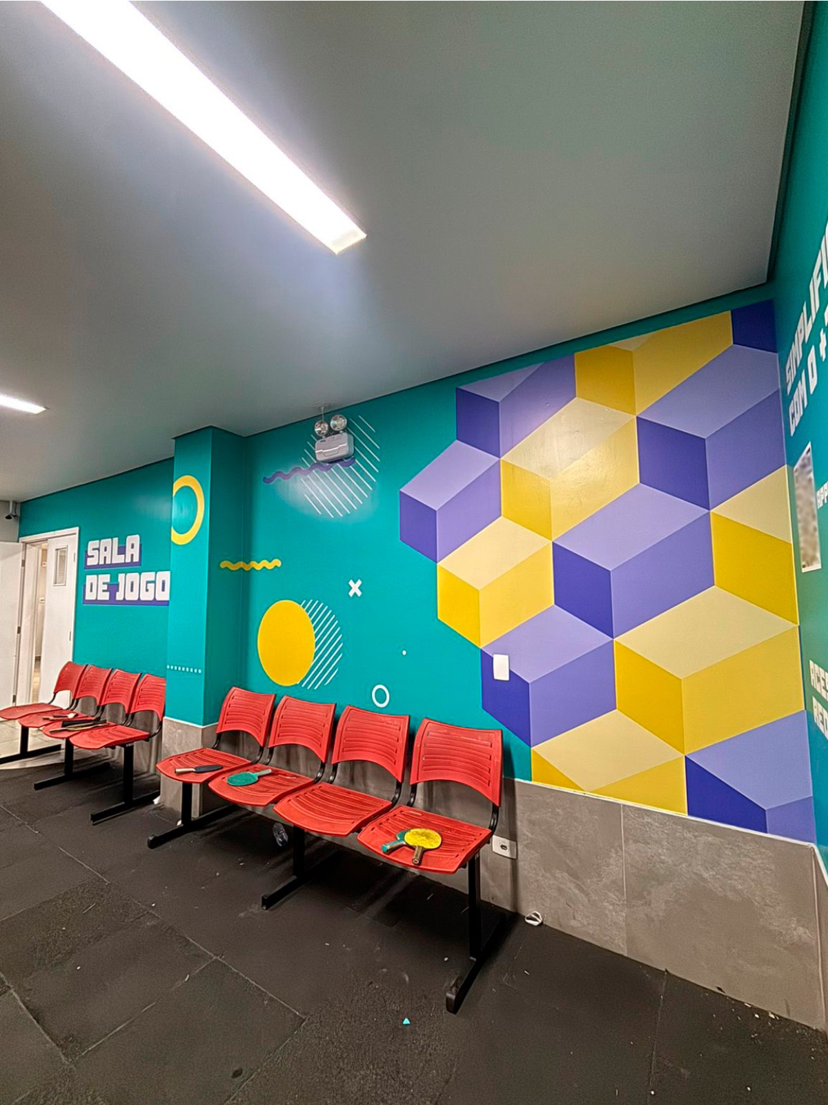 Ambientação de sala de jogos com grafismo geométrico